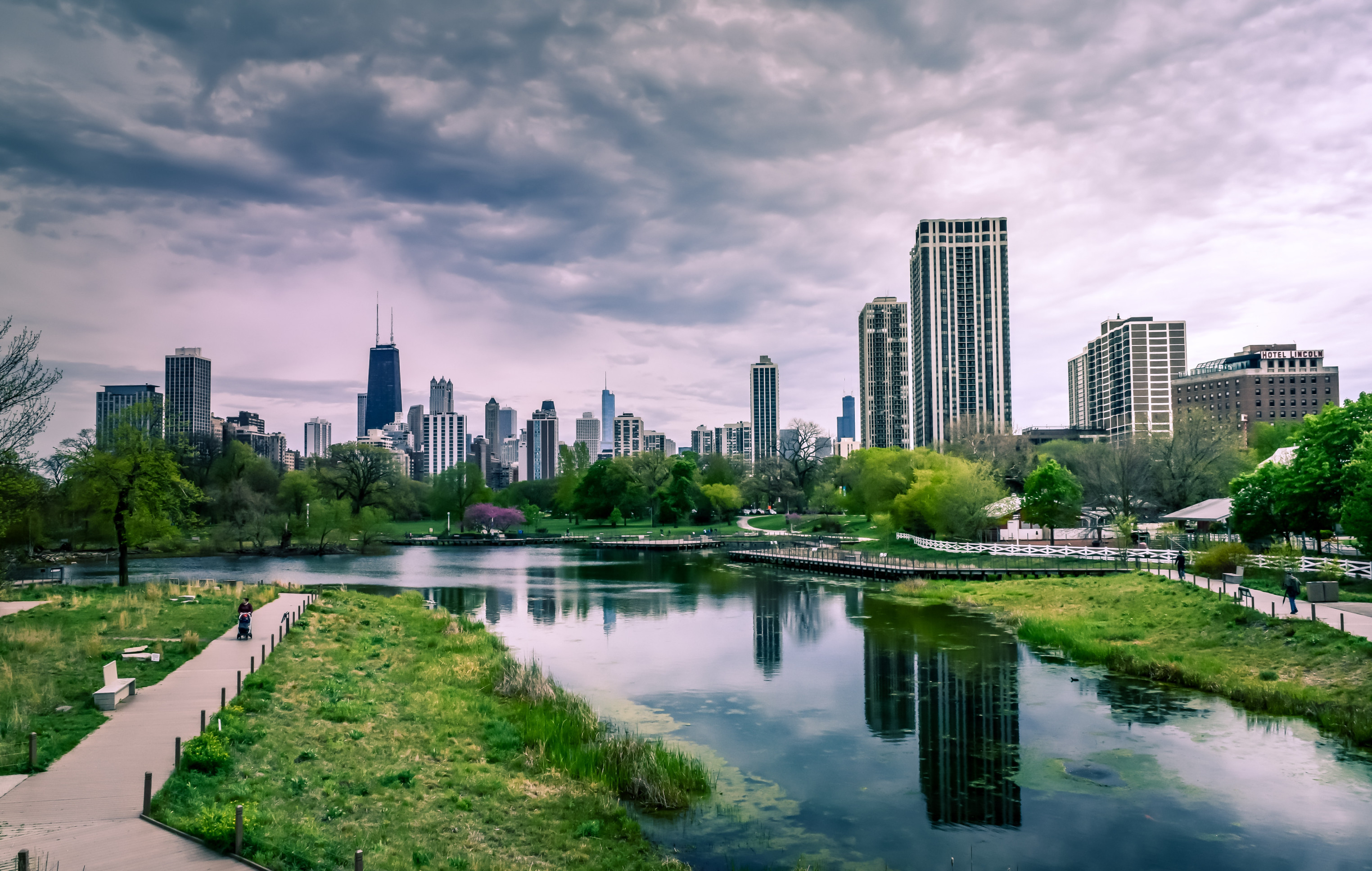 Eine Stadt ist zu sehen mit vielen Hochhäusern, aber auch viel Grünfläche und Wasser.