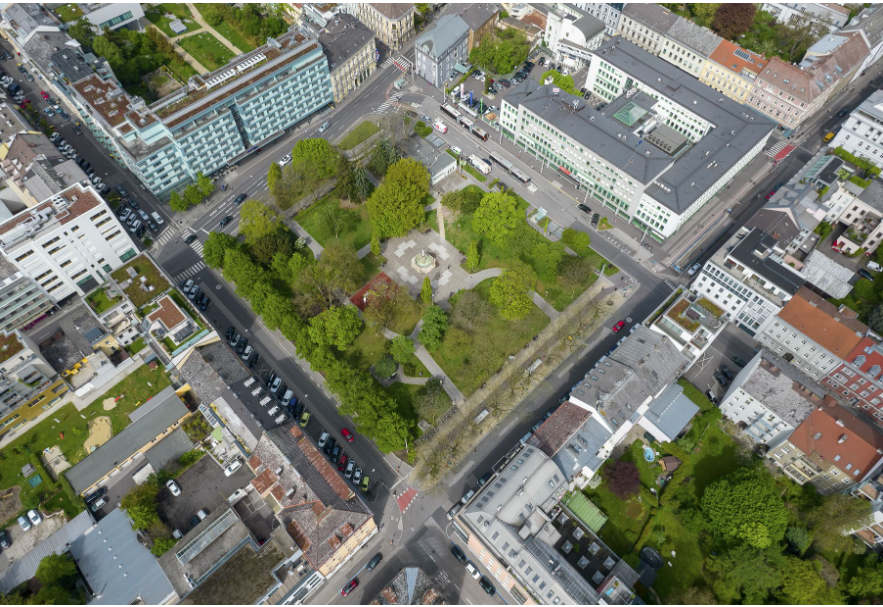 Aus der Vogelperspetive sieht man Linz. Zwischen lauter hohen Betongebäuden liegt ein grüner Park