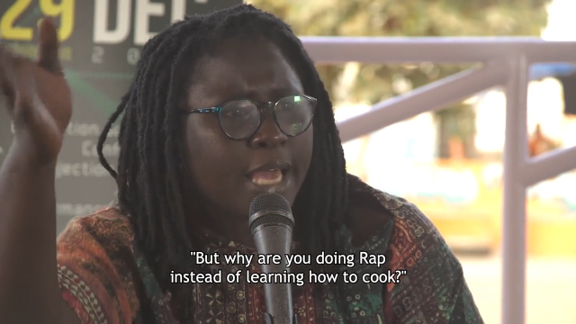 Die senegalsiche Rapperin Toussa zitiert einen Freund. Das Zitat ist als Untertitel zu lesen: "But why are you doing Rap instead of learning how to cook?"