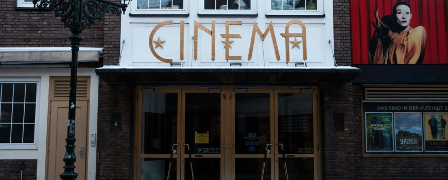 wyron-a--H_UfY36ASA-unsplash Ein altes Kino, Außenansicht. Zu lesen ist die Schrift "Cinema".